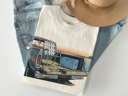 White t-shirt with illustration of a vintage pickup truck filled with fishing gear.