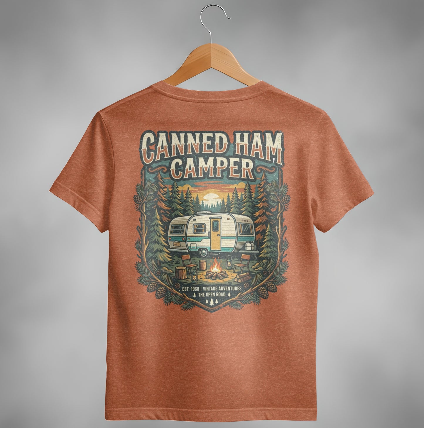 Orange t-shirt with vintage camper, campfire, and forest graphic.